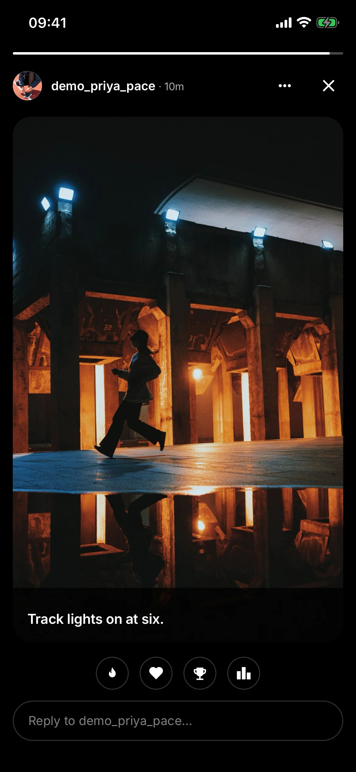 A story open full-screen: a night-time photograph of a runner under stadium lights, the caption Track lights on at six., quick reactions and a reply box.