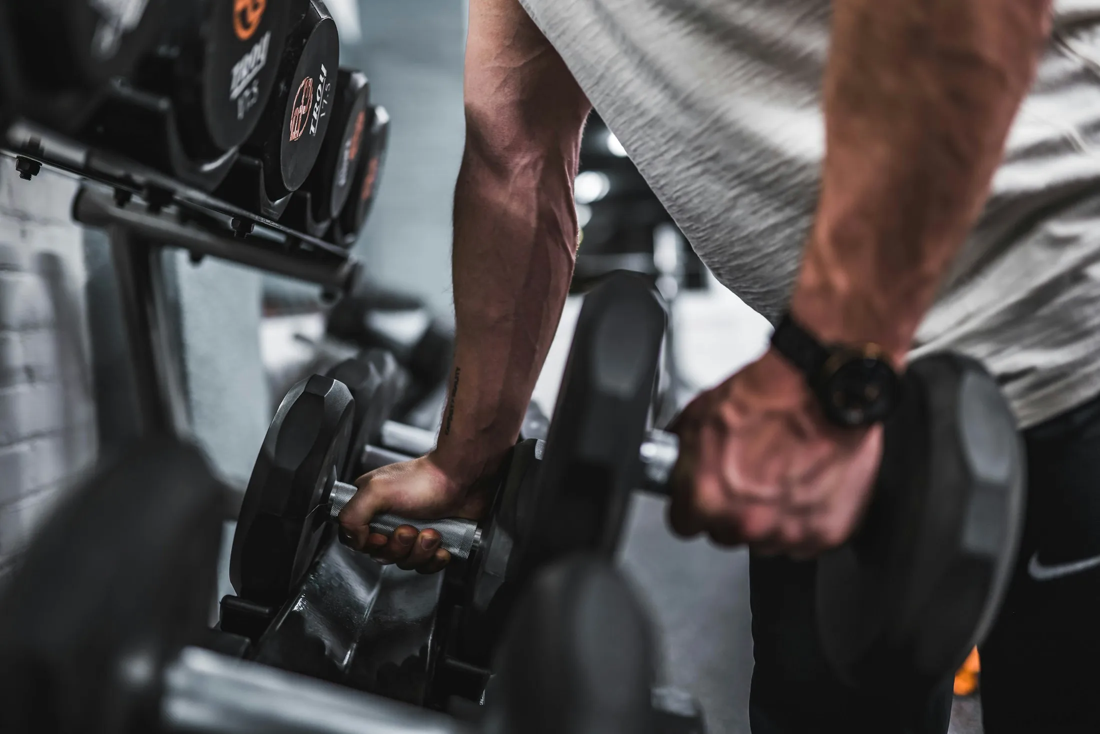 Dumbbell rows in a home gym, late evening.