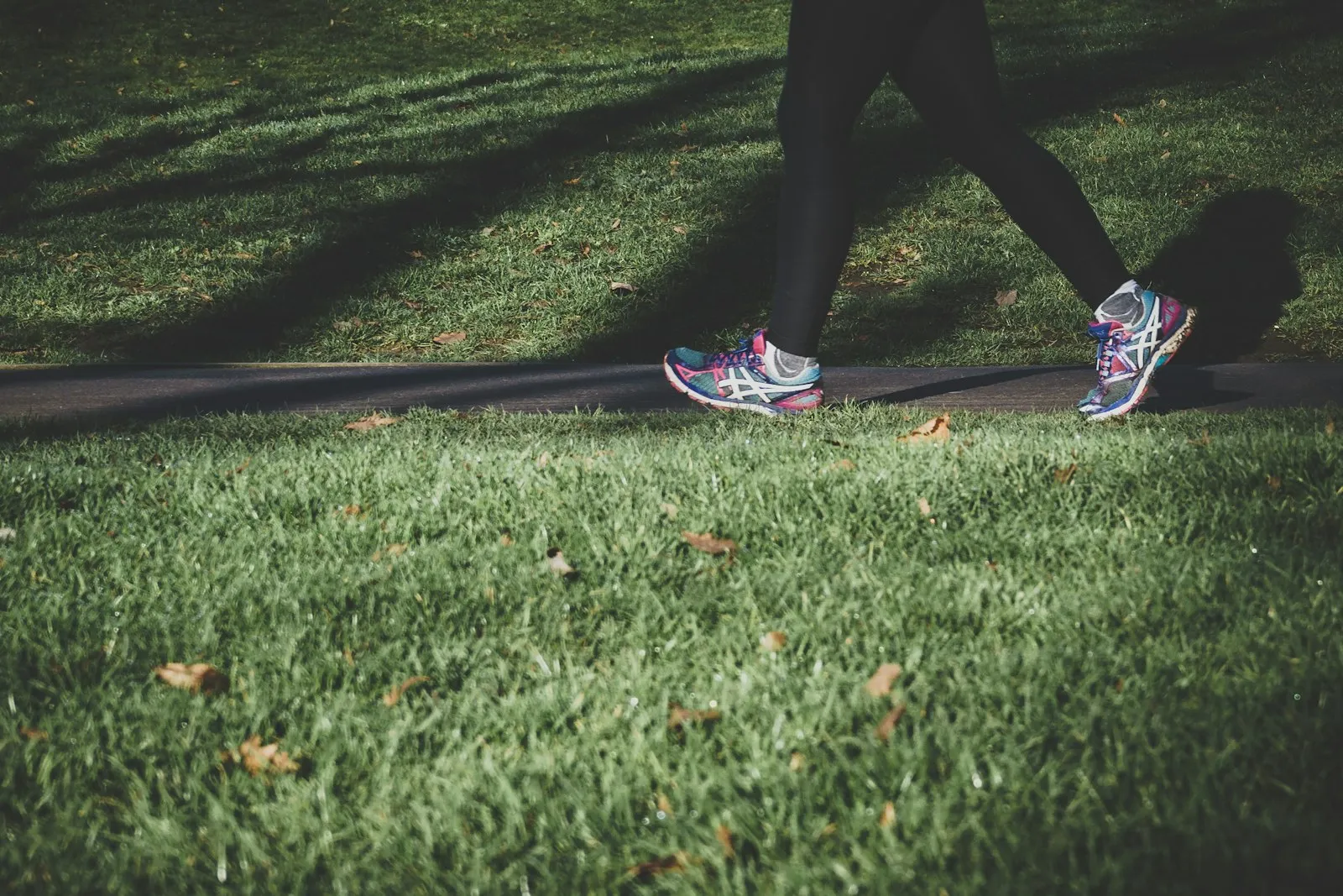 A power walker mid-stride on a park path.